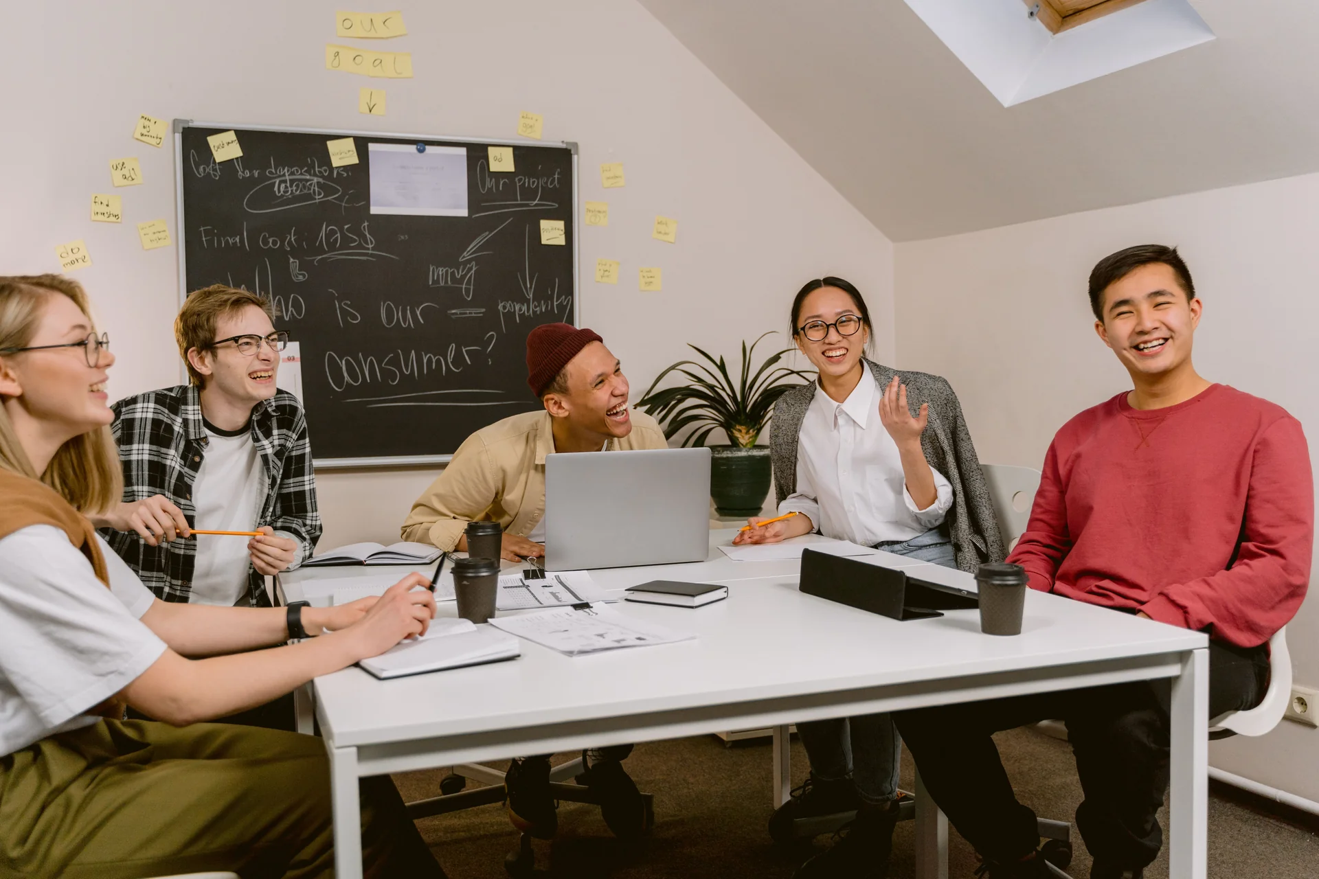 Young professionals laughing together during a meeting in a modern office