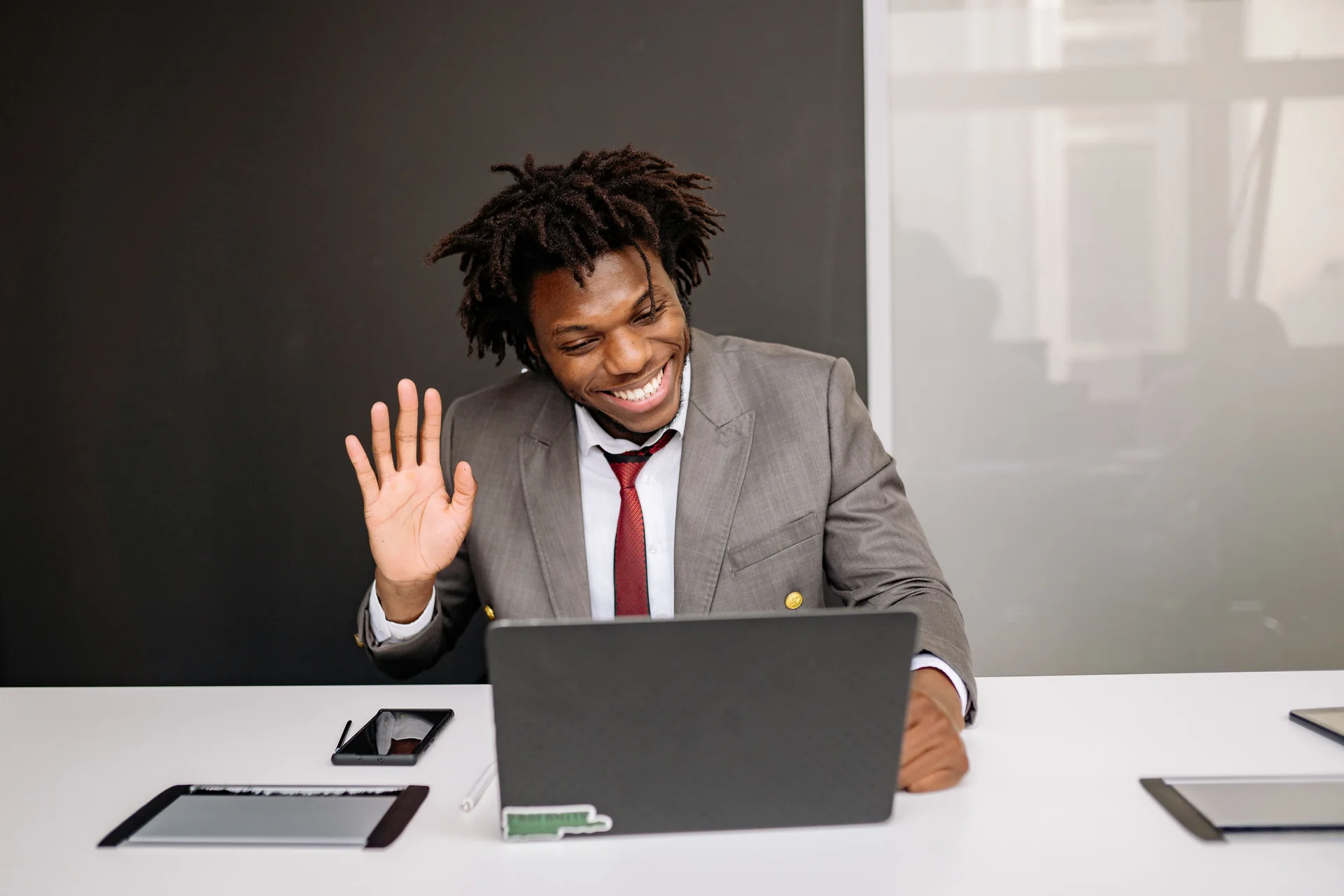 Man waving at his laptop screen during a video call